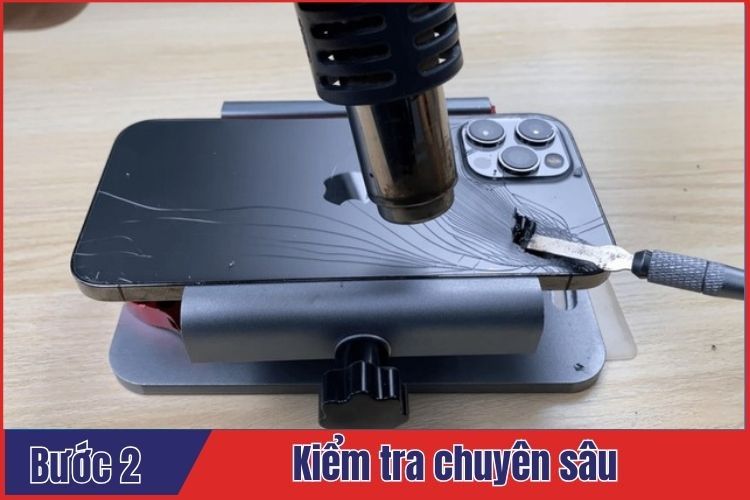 Kỹ thuật viên tiến hành kiểm tra chi tiết điện thoại trước khi thay kính lưng