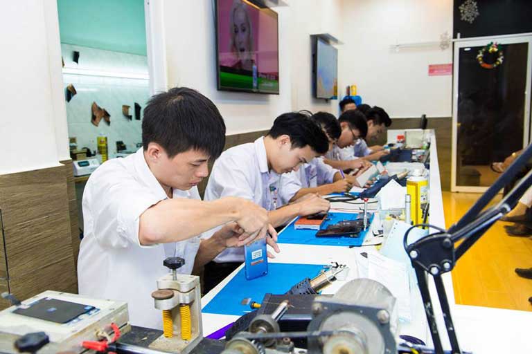 kỹ thuật viên đang sửa chữa điện thoại S9 cho khách hàng